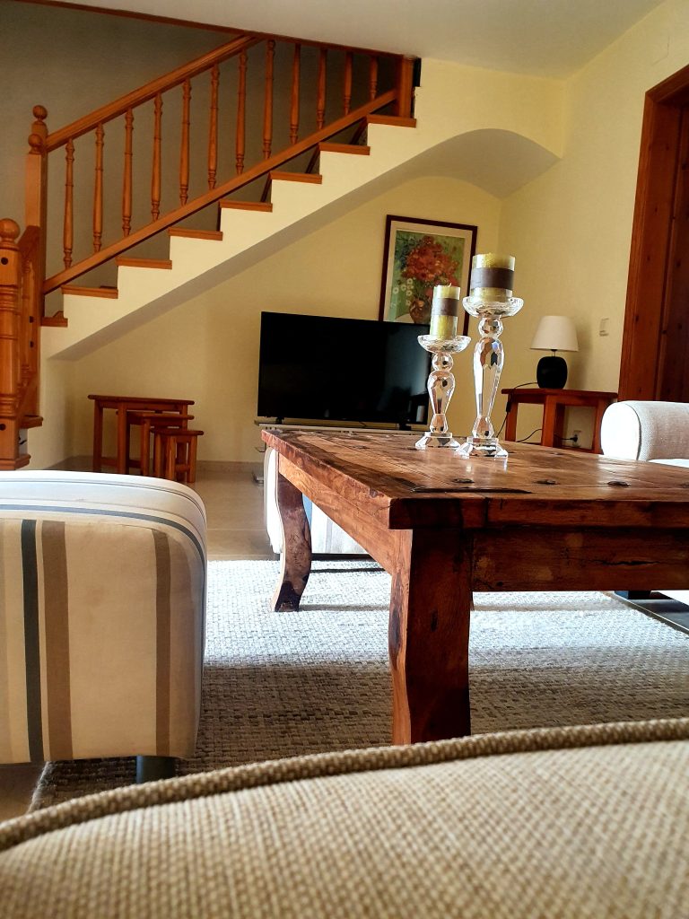 Salón con mesa de madera y zona de estar en Casa DeltaNatura