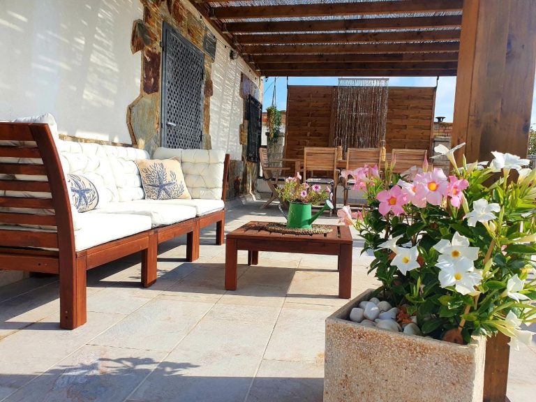 Terraza cubierta con sofás exteriores en Casa DeltaNatura